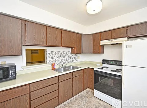 A kitchen with brown cabinets and a white fridge.