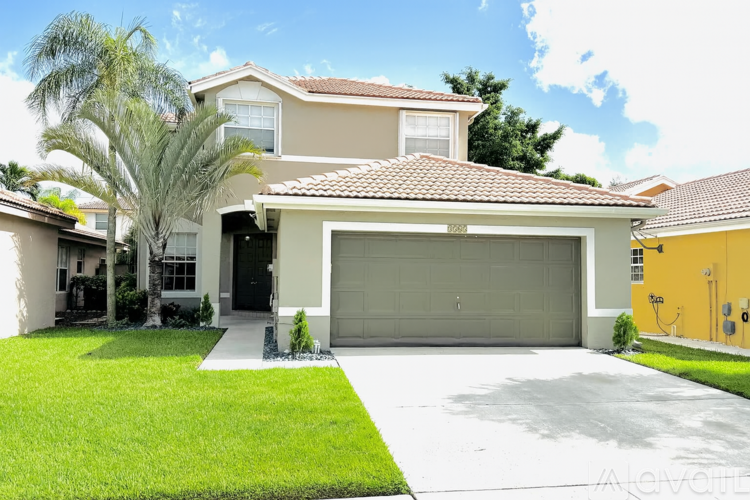 A house with a garage and a driveway in front of it.