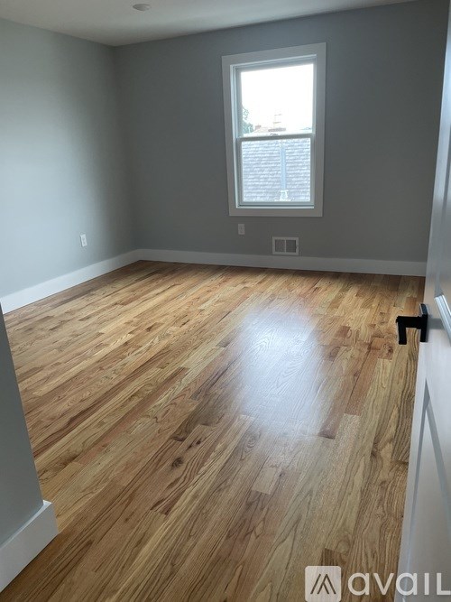 A room with wooden flooring and a window.