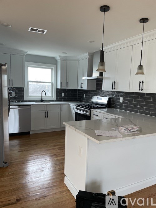 A kitchen with white cabinets and a black stove top oven.