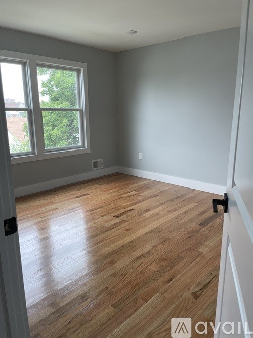 A room with wooden flooring and a window.