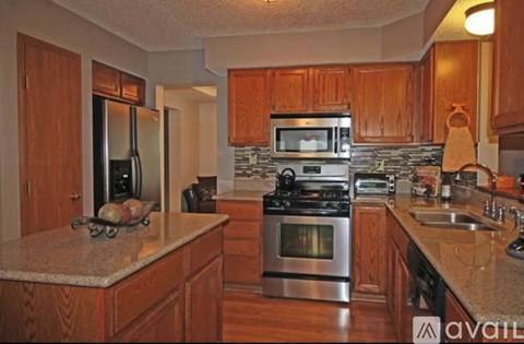 A kitchen with wooden cabinets and granite countertops.