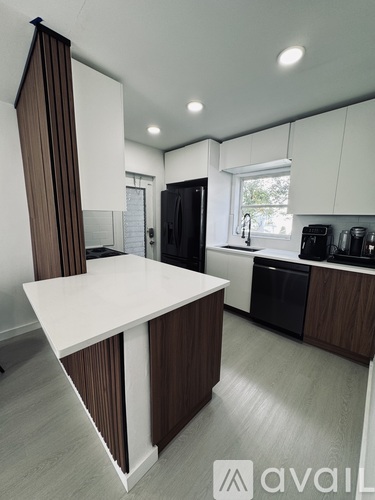 A kitchen with white countertops and dark brown cabinets.