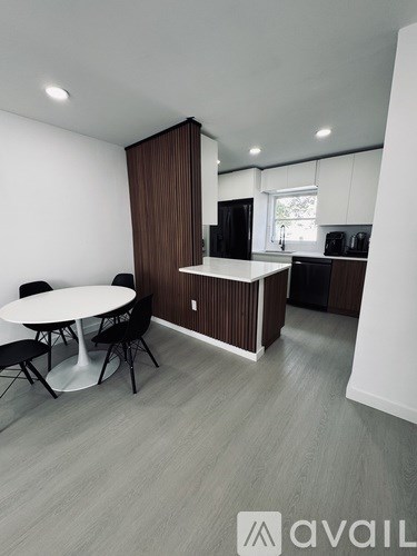 A modern kitchen with a dining table and chairs.