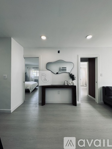 A modern bedroom with a large bed and a mirrored headboard.