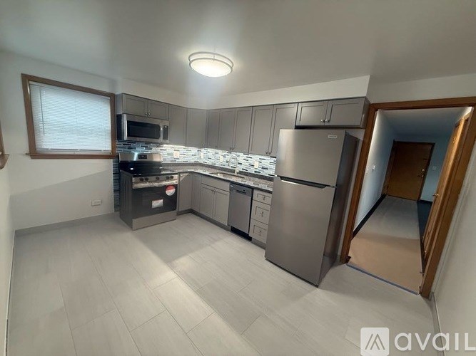 A kitchen with stainless steel appliances and a tile backsplash.