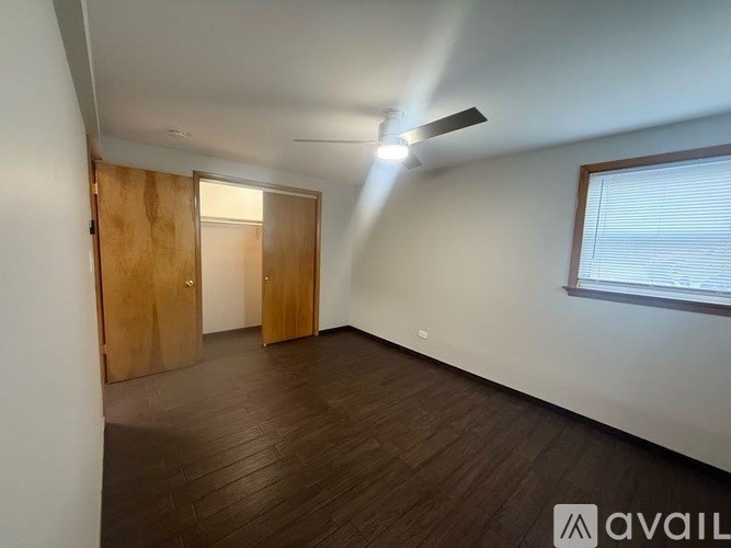 A room with wooden floors and two doors, one of which is open.