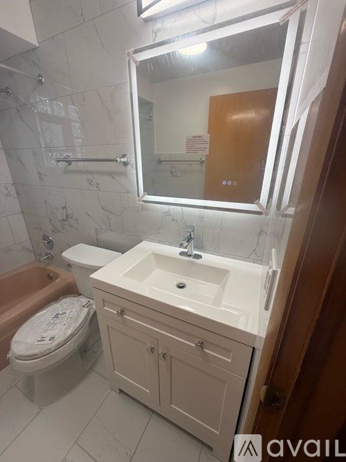 A bathroom with a white sink, brown toilet, and a brown door.