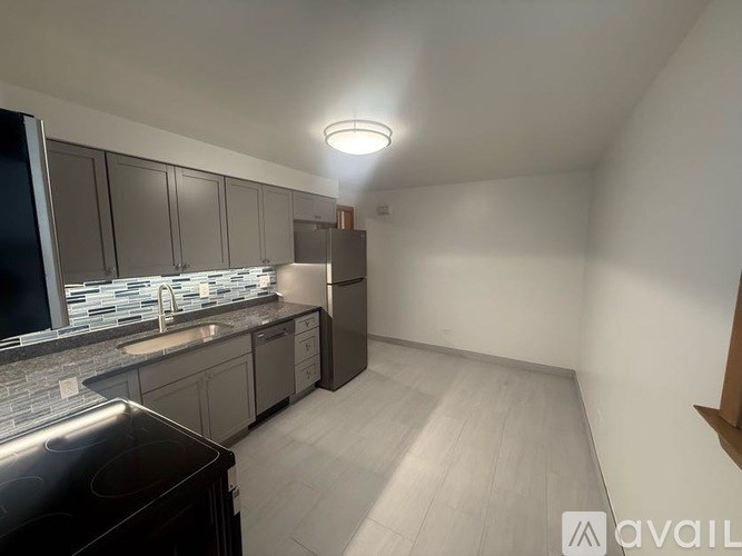 A kitchen with a black stove top oven and a counter top with a sink.