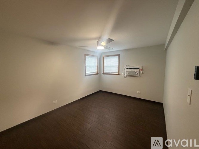 A room with wooden flooring and a window.