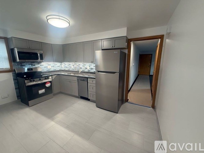 A kitchen with a refrigerator, microwave, and oven.