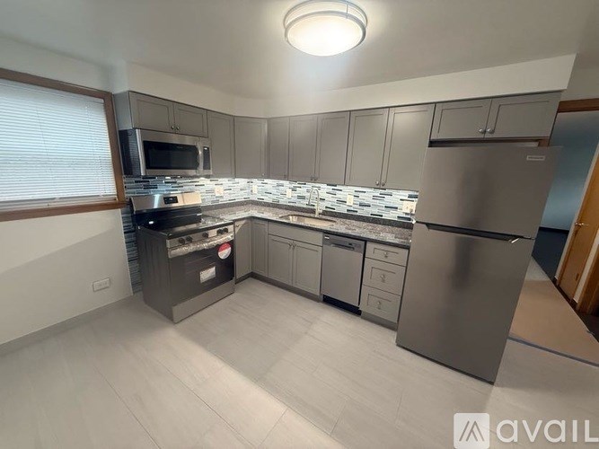 A kitchen with a refrigerator, stove, and microwave.