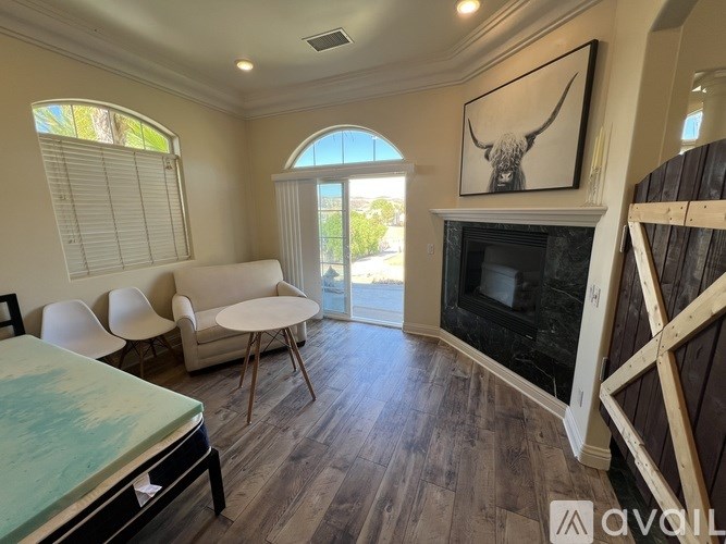 A living room with a fireplace and a painting of a bull on the wall.