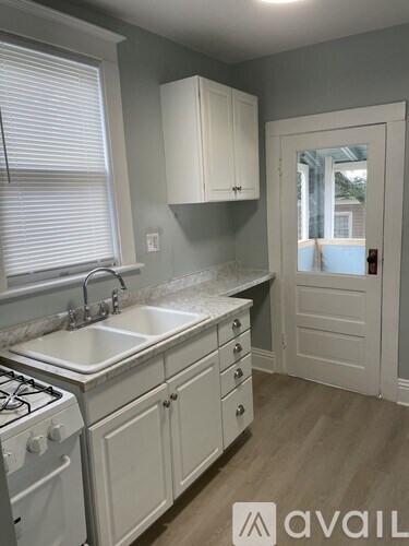 A kitchen with white cabinets and a stove top oven.