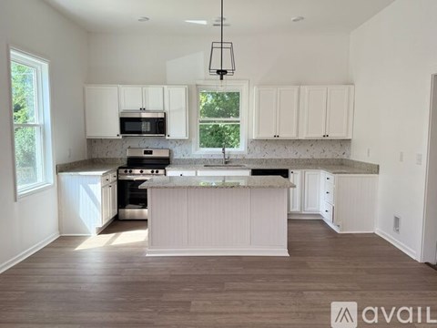 A kitchen with white cabinets and a marble countertop.