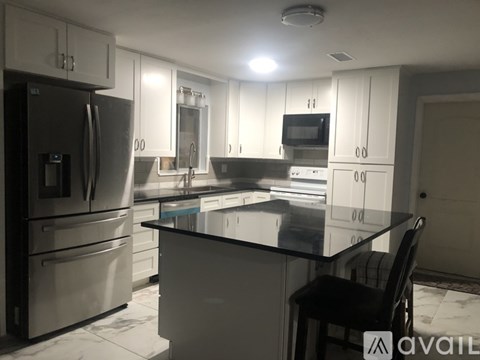 A kitchen with a black countertop and stainless steel appliances.