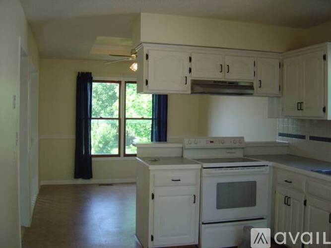 A kitchen with white appliances and cabinets.