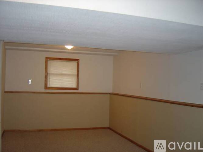 A room with a window and a light on the ceiling.