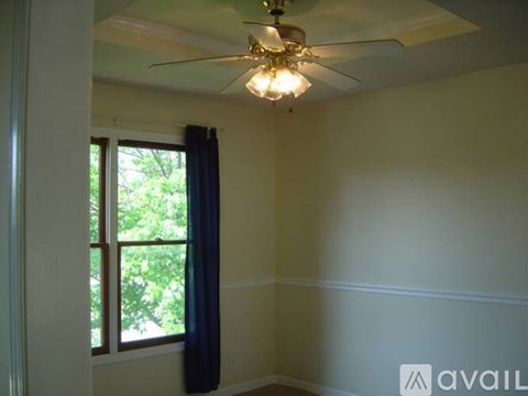A room with a ceiling fan and a window.