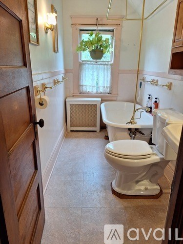 A bathroom with a toilet, tub, and window.