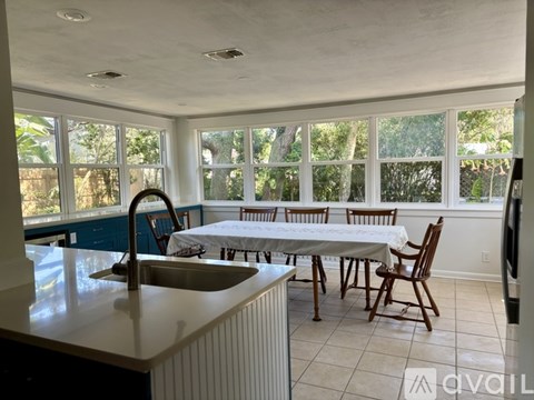 A kitchen with a table and chairs in front of a window.