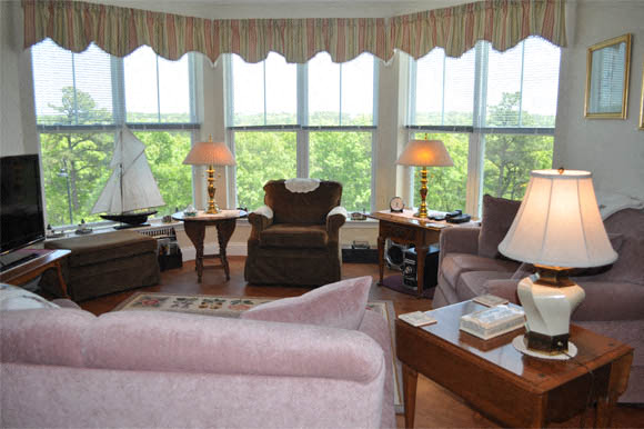 A living room with a pink couch and a white lamp.