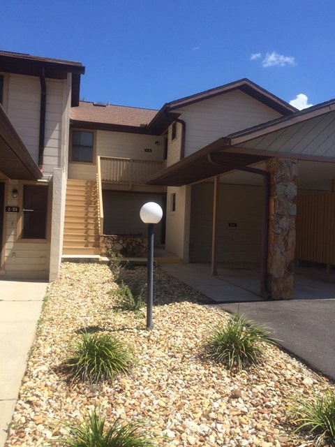 A house with a brown roof and a gravel driveway.