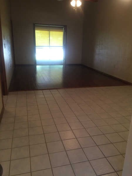 A room with a tiled floor and a door leading to a balcony.