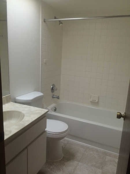 A white toilet and sink in a small bathroom.