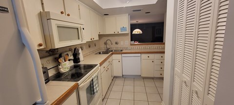 A kitchen with white cabinets and a black stove top.