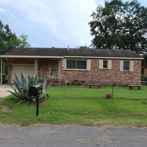 A brick building with a mailbox in front of it.