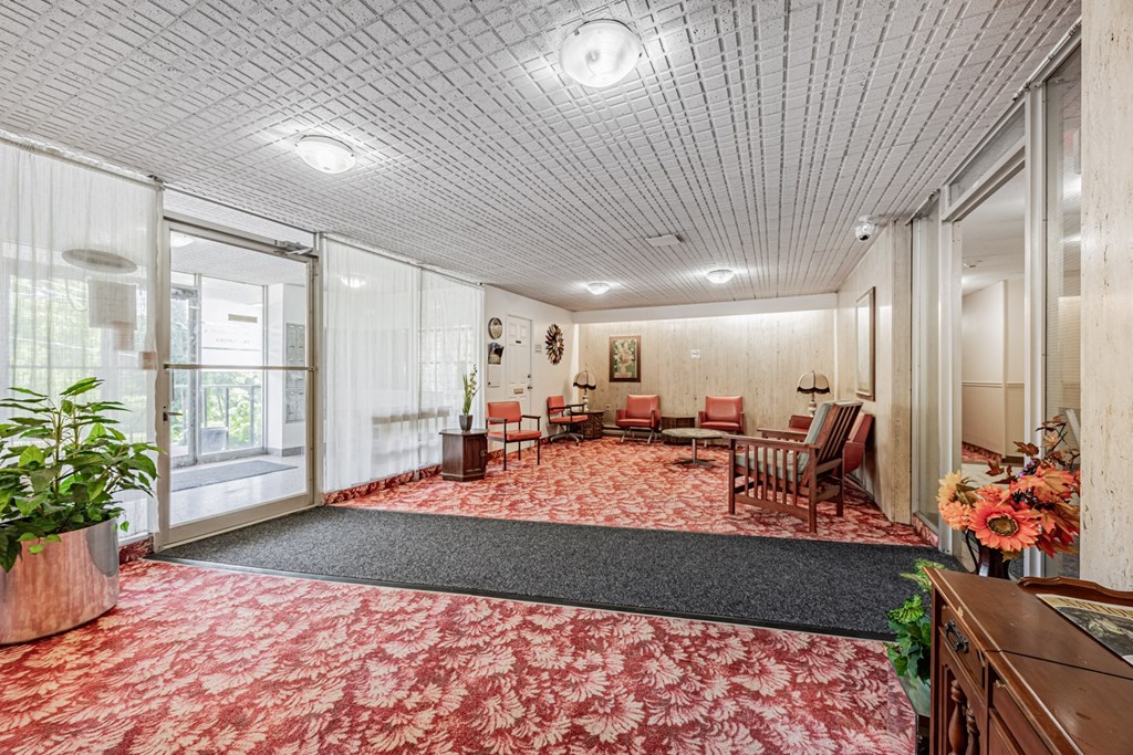 A room with a red carpet and wooden furniture.