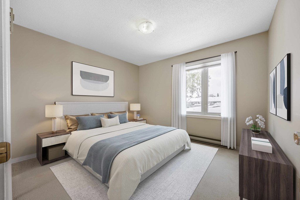 A bedroom with a large bed and a window with curtains.