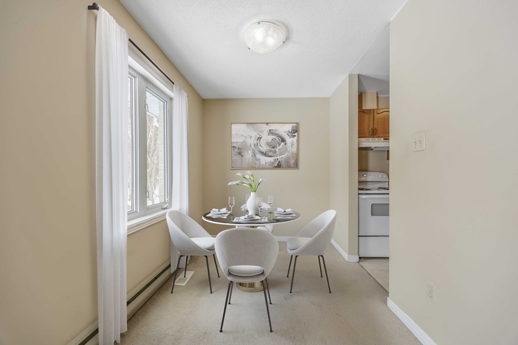 A dining room with a table set for four.