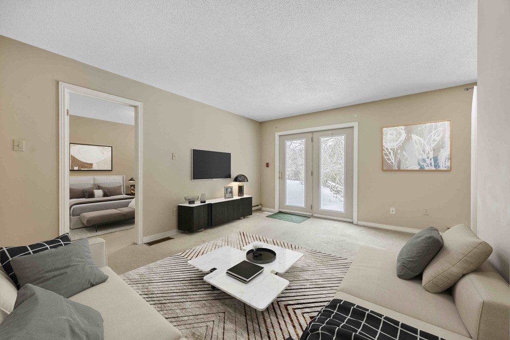 A living room with a couch, coffee table, and television.