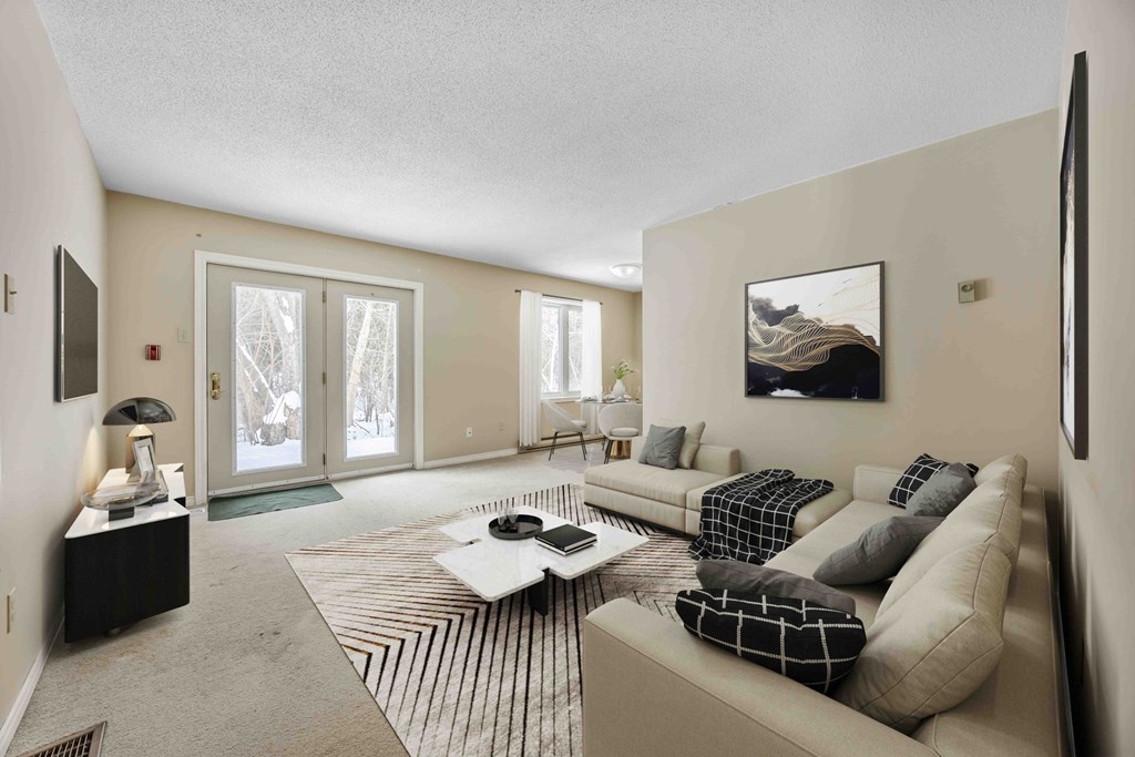 A living room with a couch, coffee table, and a painting on the wall.