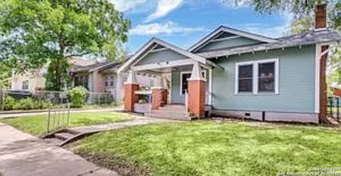 A house with a green front yard and a white fence.