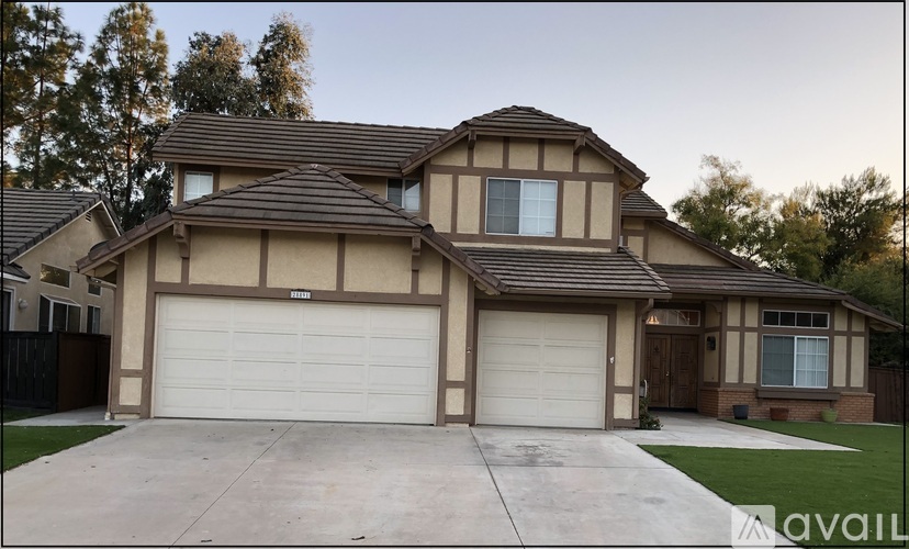A house with a brown and beige exterior and a white garage door.