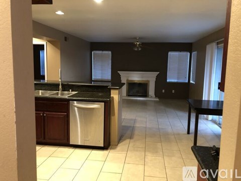 A kitchen with a black counter top and a white sink.