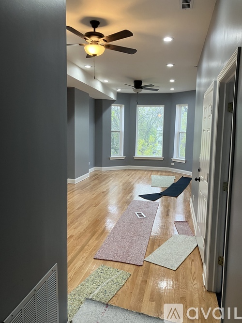 A room with a ceiling fan and wooden flooring.