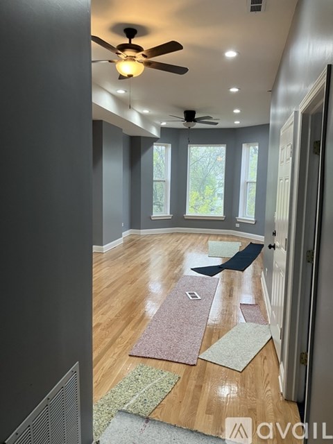 A room with a ceiling fan and wooden flooring.