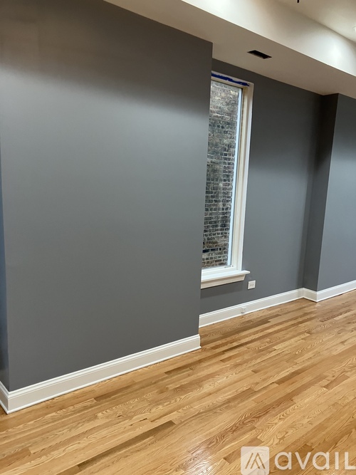 A room with wooden flooring and a window.