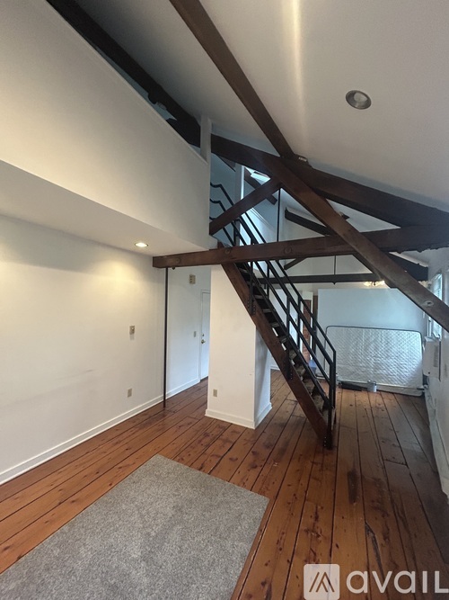 A wooden staircase with a metal railing leads up to a second floor.