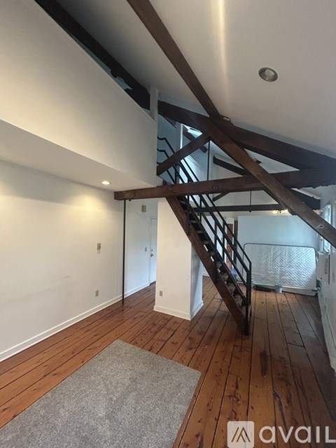 A wooden staircase with a metal railing leads up to a second floor.