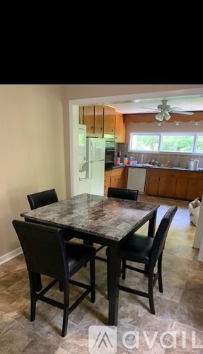 A kitchen with a table and chairs in the foreground.