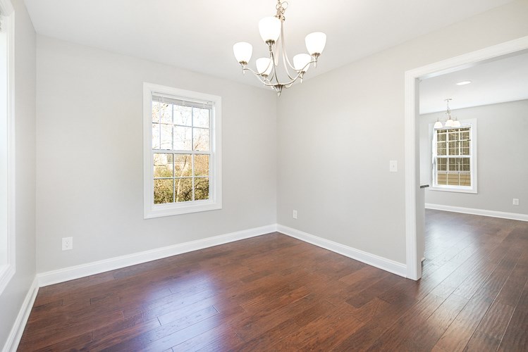 A room with a chandelier and a window with a view of trees.
