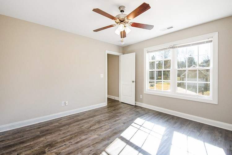 A room with a ceiling fan and a window.