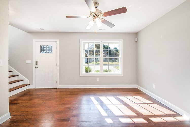 A room with a ceiling fan and a window.