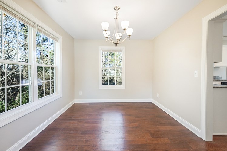 A room with a chandelier and a window overlooking trees.