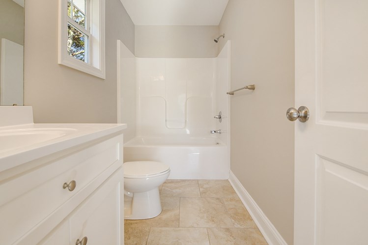 A white bathroom with a toilet, sink, and bathtub.